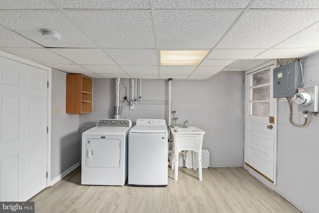 laundry room featuring light wood-type flooring, laundry area, electric panel, and separate washer and dryer