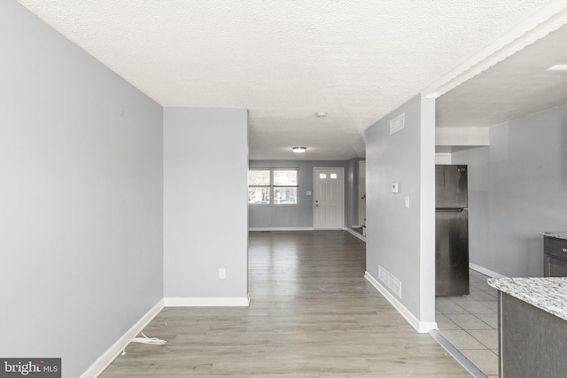 interior space with wood finished floors, visible vents, and baseboards