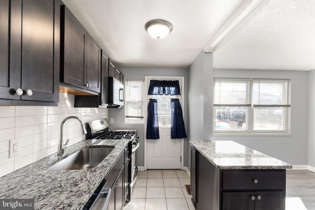 kitchen with stainless steel appliances, a wealth of natural light, a sink, and tasteful backsplash