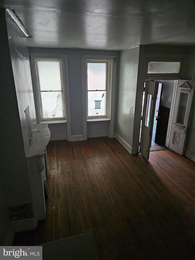 spare room featuring dark wood finished floors and baseboards