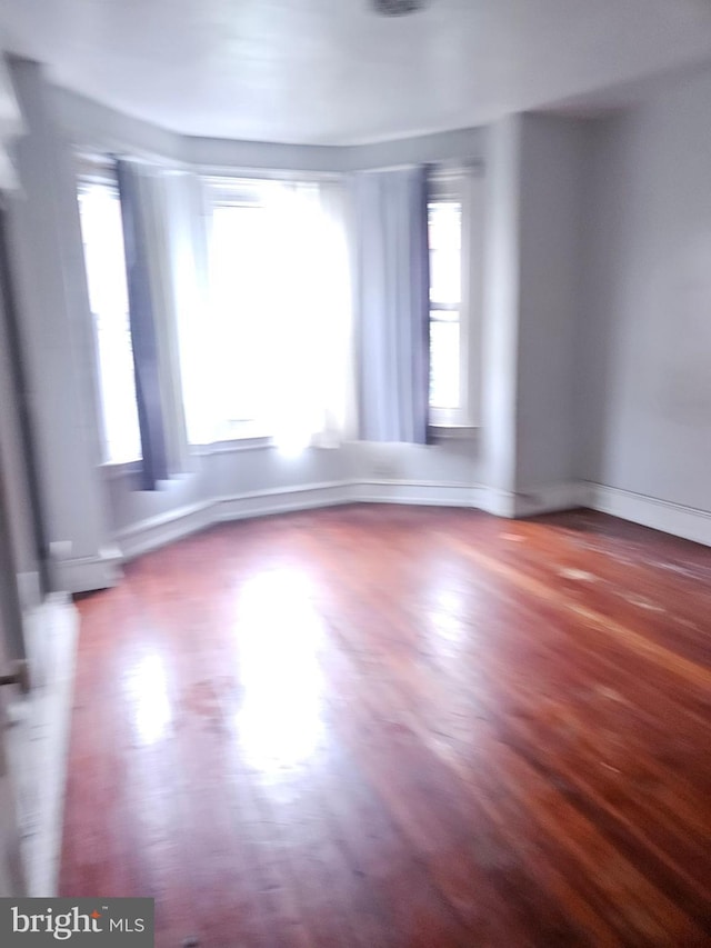 empty room featuring baseboards and wood finished floors