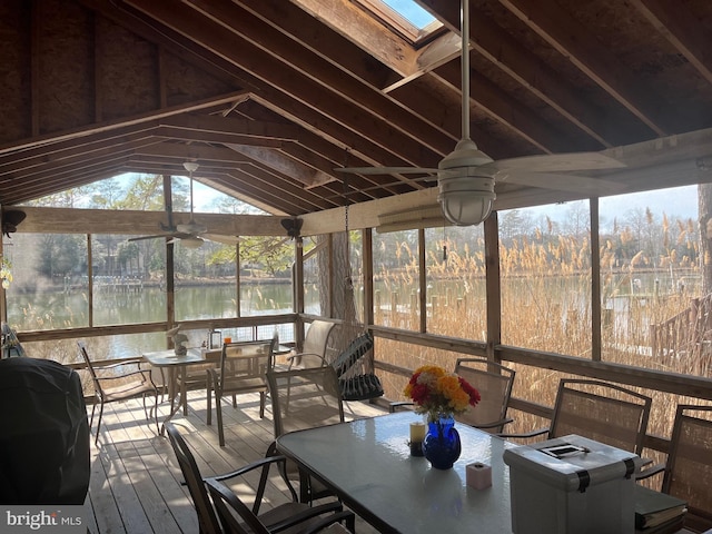 unfurnished sunroom with a water view, lofted ceiling with skylight, and ceiling fan