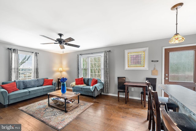 living room featuring ceiling fan, dark wood-style flooring, and baseboards