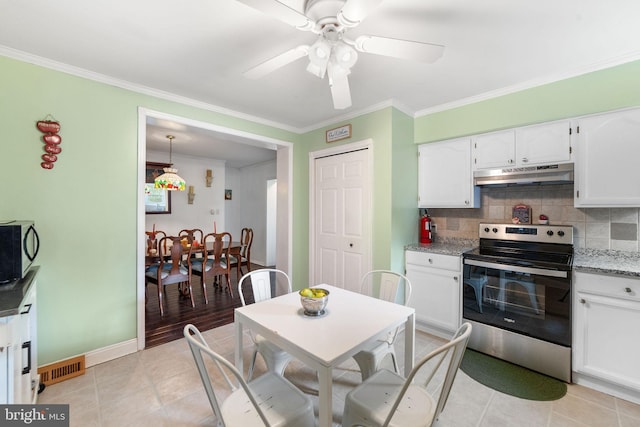 kitchen with light stone counters, stainless steel electric range oven, decorative backsplash, white cabinetry, and under cabinet range hood