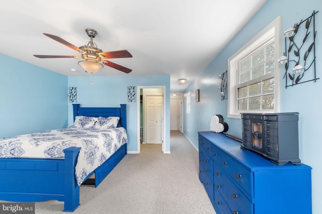 bedroom featuring light carpet, ceiling fan, and baseboards