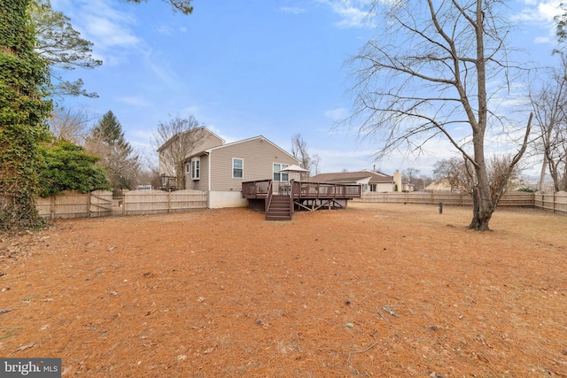 exterior space with stairway, a fenced backyard, and a wooden deck