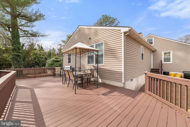 wooden deck with outdoor dining space and grilling area