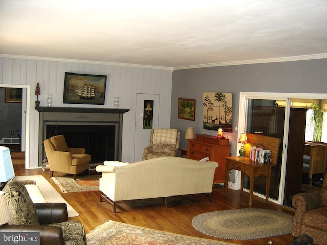 living area featuring crown molding, a fireplace, and wood finished floors