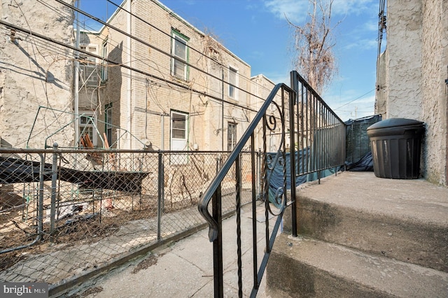 view of side of property featuring brick siding and fence