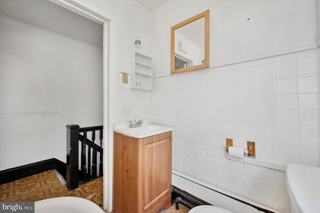 half bathroom with vanity, toilet, and tile walls