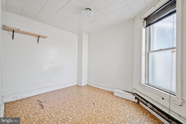 unfurnished room with baseboards, light floors, ornamental molding, and a healthy amount of sunlight