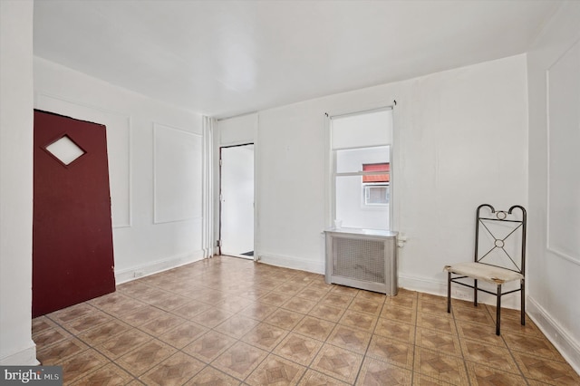 spare room with radiator heating unit and baseboards