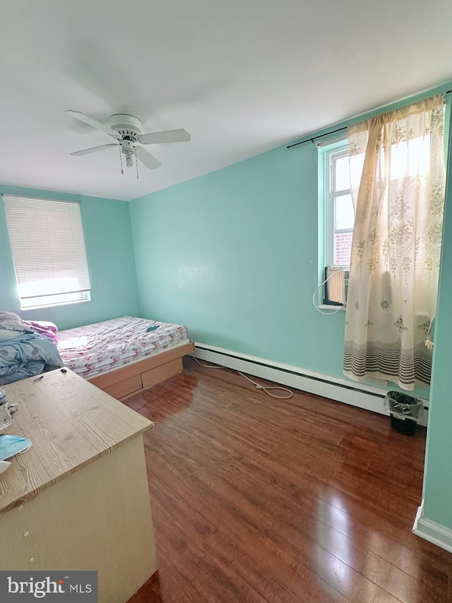 bedroom featuring ceiling fan, baseboard heating, cooling unit, and wood finished floors