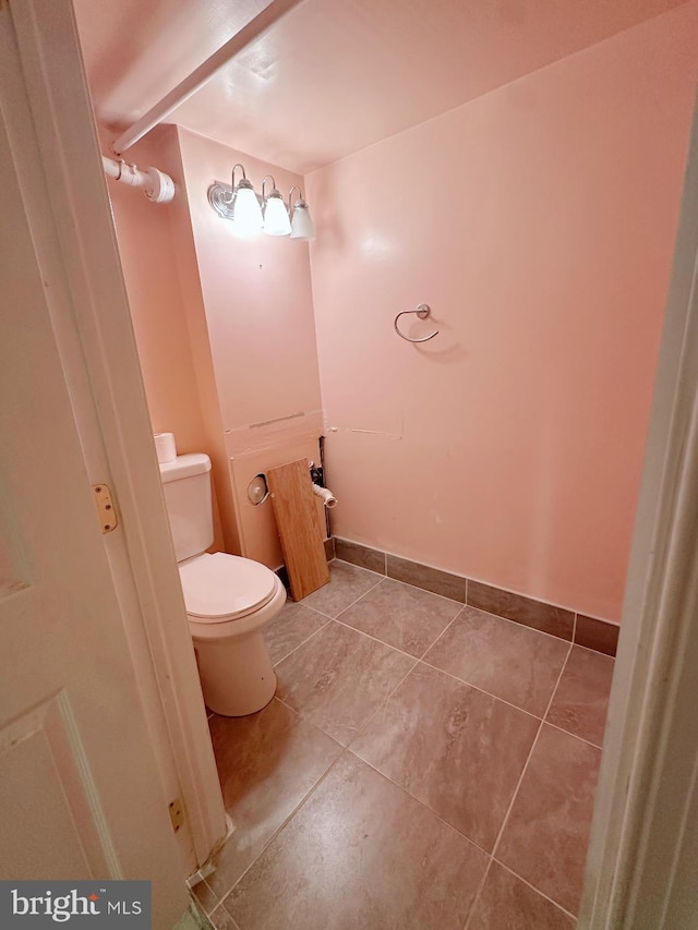 bathroom with baseboards, toilet, and tile patterned floors