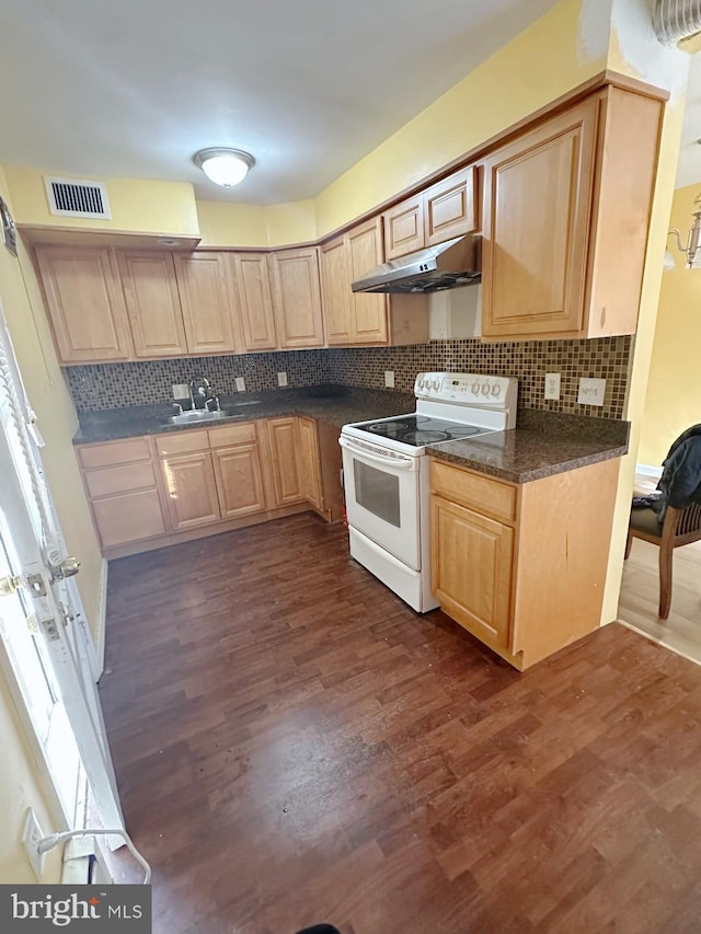 kitchen featuring white electric stove, dark countertops, light brown cabinets, a sink, and under cabinet range hood