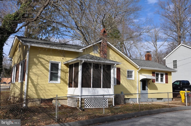 view of front of property with crawl space, a sunroom, a chimney, and fence private yard