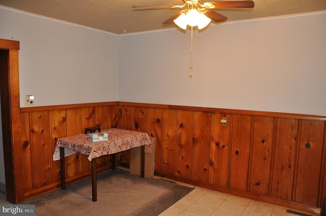 dining area with ceiling fan, wainscoting, and crown molding