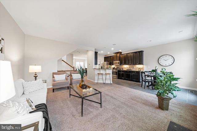 living area featuring baseboards, carpet floors, stairs, and recessed lighting