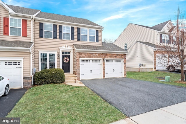 view of front of home featuring a garage, roof with shingles, aphalt driveway, and a front yard