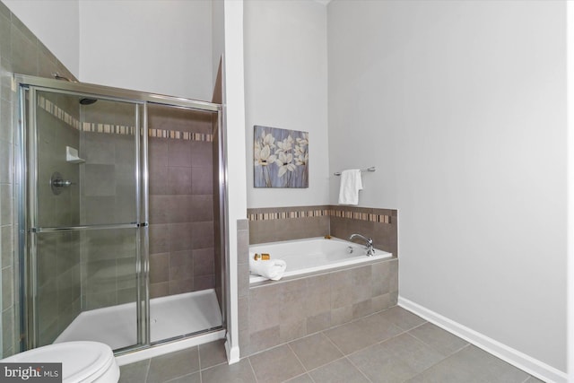 bathroom with a stall shower, baseboards, toilet, tile patterned floors, and a garden tub