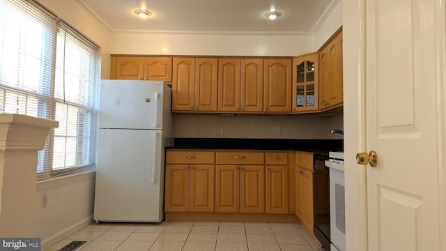 kitchen featuring light tile patterned floors, freestanding refrigerator, decorative backsplash, glass insert cabinets, and crown molding