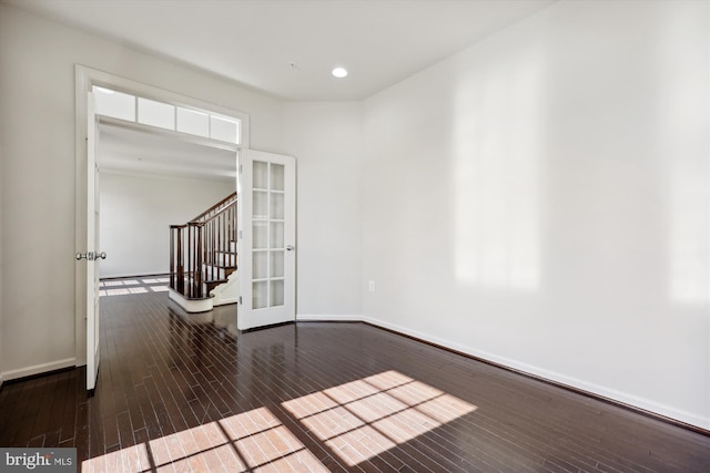 empty room featuring stairway, recessed lighting, wood finished floors, and baseboards