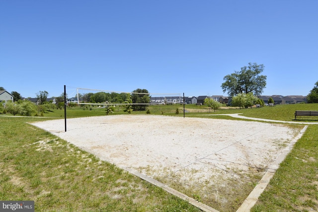 view of property's community with a lawn and volleyball court