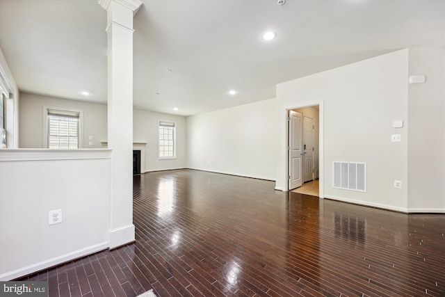 unfurnished living room featuring decorative columns, visible vents, wood finished floors, a fireplace, and recessed lighting