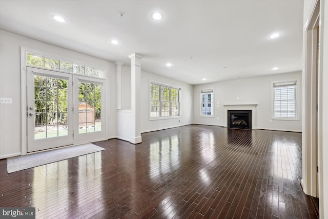 unfurnished living room featuring hardwood / wood-style floors, a glass covered fireplace, a wealth of natural light, and recessed lighting