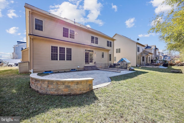 rear view of house with entry steps, a patio, a residential view, and a lawn