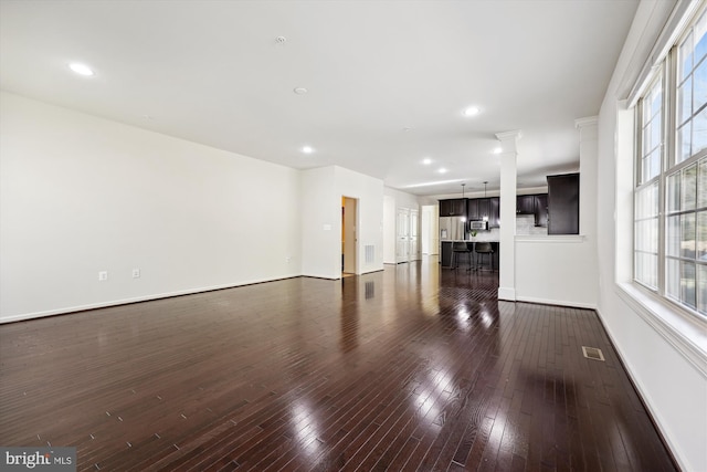 unfurnished living room with visible vents, baseboards, dark wood finished floors, and recessed lighting