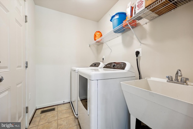 laundry room featuring laundry area, light tile patterned floors, visible vents, washer and clothes dryer, and a sink