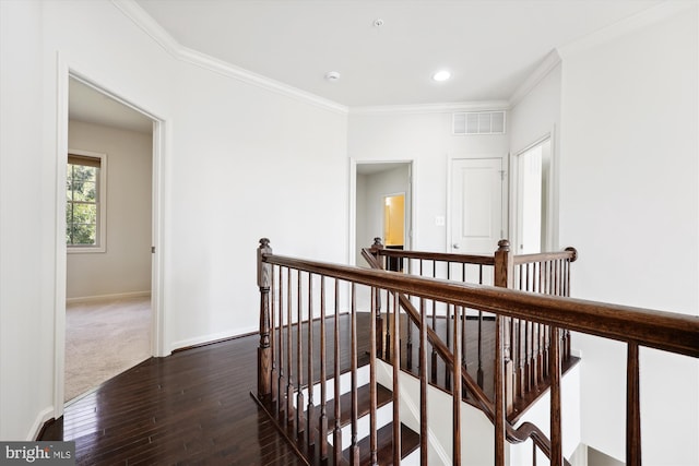 corridor featuring baseboards, dark wood-style flooring, an upstairs landing, and crown molding