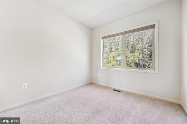 unfurnished room featuring carpet floors, visible vents, and baseboards