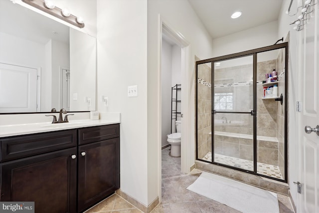 full bathroom with a stall shower, baseboards, vanity, and toilet