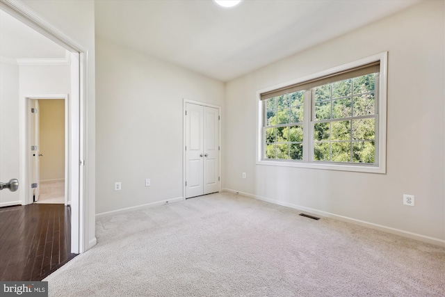 unfurnished bedroom with carpet floors, a closet, visible vents, and baseboards