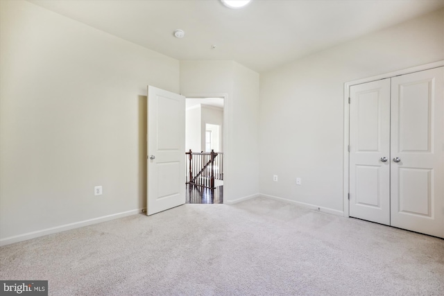 unfurnished bedroom featuring carpet floors, a closet, and baseboards