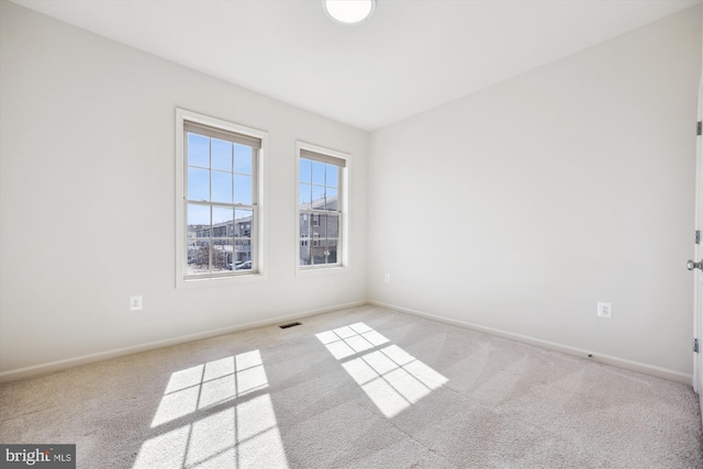 unfurnished room featuring baseboards, visible vents, and carpet flooring