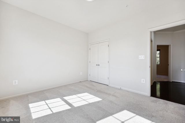 unfurnished bedroom featuring a closet, carpet flooring, and baseboards