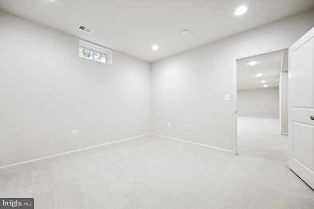 basement with light carpet, baseboards, visible vents, and recessed lighting