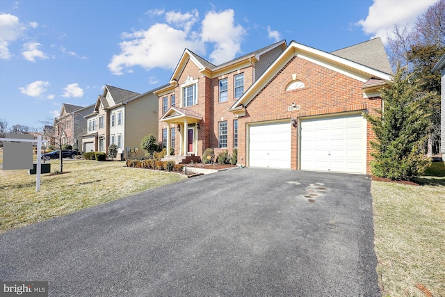 view of front of property with brick siding, an attached garage, a residential view, driveway, and a front lawn