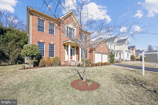 view of front of home with a garage, brick siding, a front lawn, and aphalt driveway