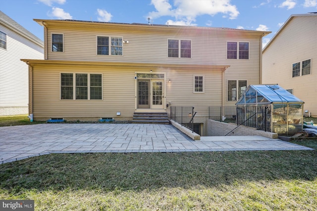 back of property with entry steps, a lawn, a patio, an outdoor structure, and an exterior structure