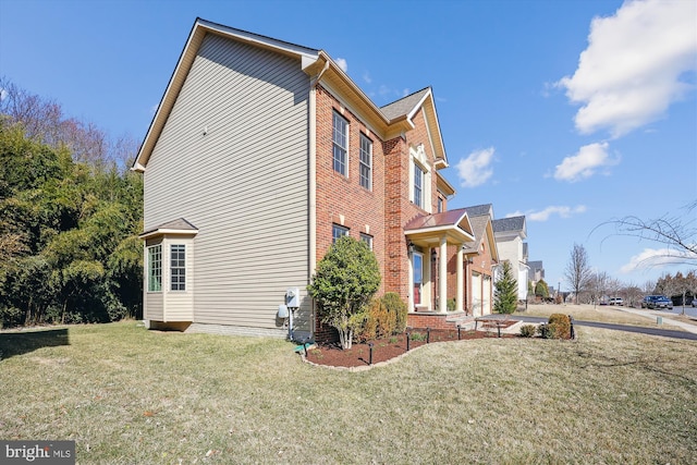 view of home's exterior featuring brick siding and a yard