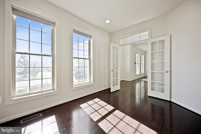 interior space featuring french doors, visible vents, baseboards, and hardwood / wood-style flooring