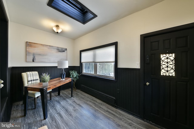 office area with a wainscoted wall, a skylight, and wood finished floors