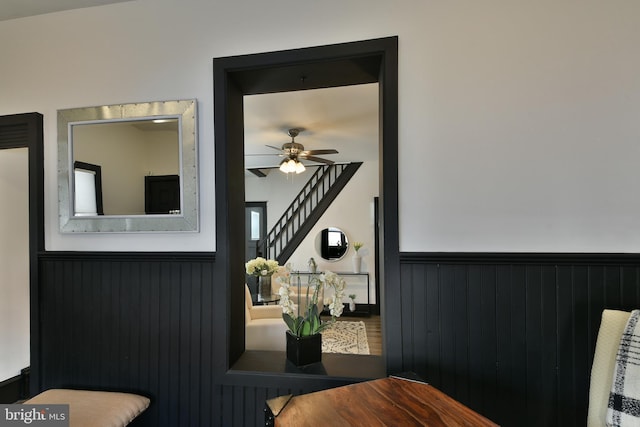 interior space featuring a ceiling fan and wainscoting