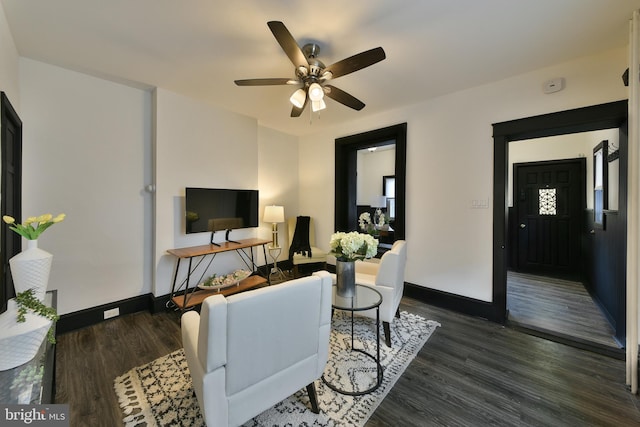 living area featuring ceiling fan, dark wood-type flooring, and baseboards