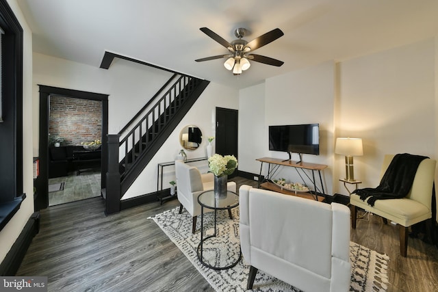 living room featuring stairs, wood finished floors, a ceiling fan, and baseboards