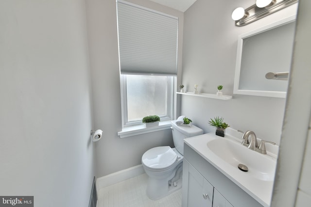 bathroom featuring toilet, tile patterned floors, vanity, and baseboards